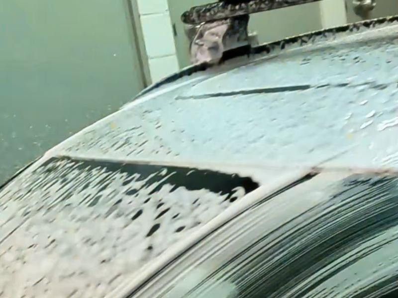 Thick foam pre-wash covering a car's roof and windscreen