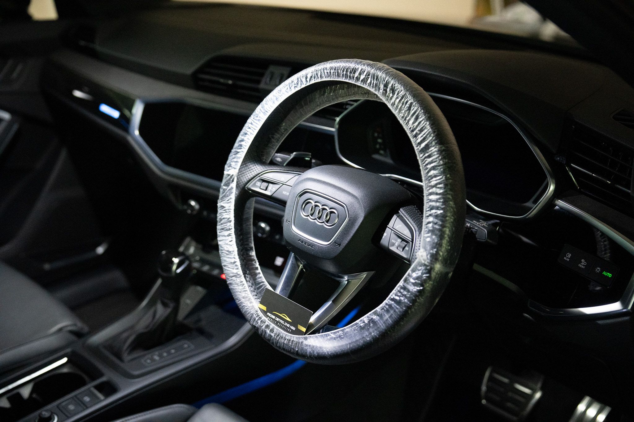 Audi RS Q3 cockpit after a detail, with a fresh steering-wheel cover and a Prime card tucked in