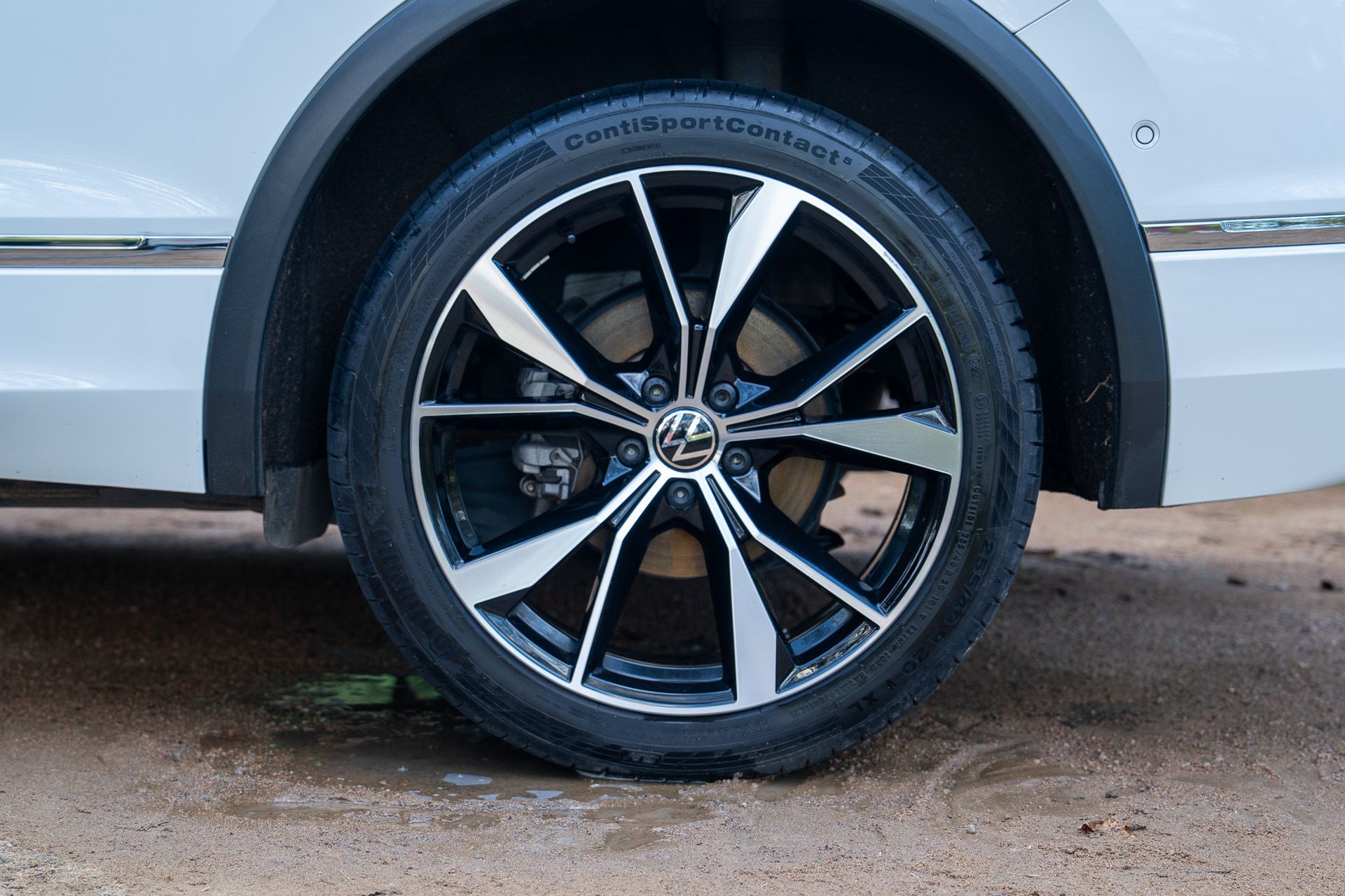 After: the same wheel clean and glossy, with the tyre black and the bumper washed